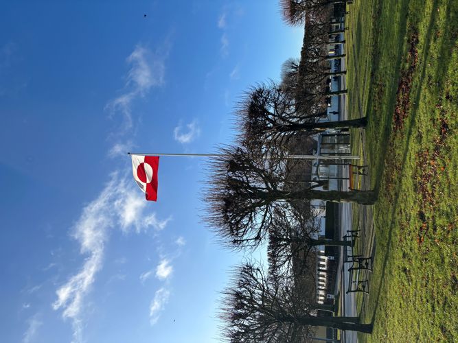 Grønlands flag med Store Magleby Kirke i baggrunden