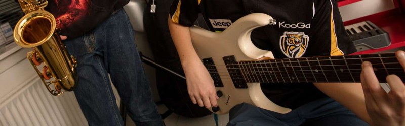 Unge spiller på saxofon og guitar